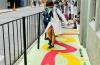 Niño camina sobre el caminito amarillo de zig zag pintado sobre la vereda 