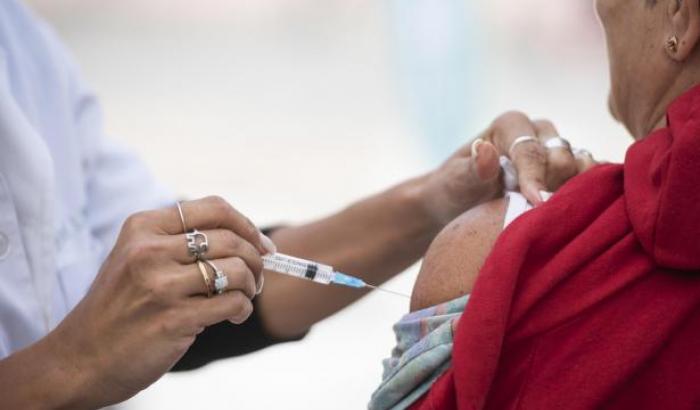 Fotografía de una escena de vacunación, de espaldas, se ve una persona mientras es vacunada 