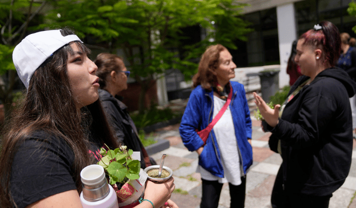 La fotografía muestra a un grupo de personas en el patio del Liceo Zorrilla conversando e intercambiando plantines 